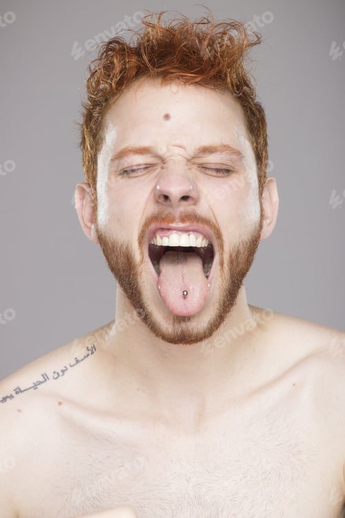 Preview: Headshot Of Ginger, Mouth Opened, Yelling, Pierced Tongue. Clean Gray Studio Background.