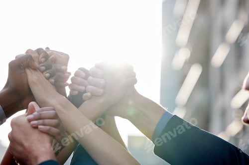 Preview: Shot of a group of unrecognizable businesspeople holding hands against a city background