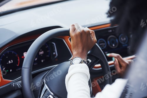 Preview: Young african american woman sits inside of new modern car