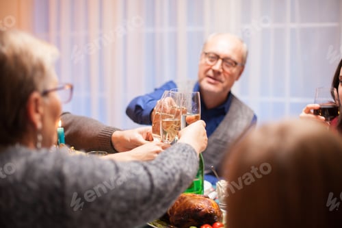 Preview: Senior man clinking a glass of wine