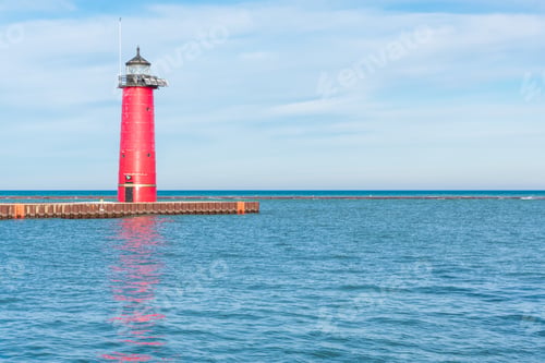 Preview: Red lighthouse illuminated by the sunlight along beautiful Lake Michigan