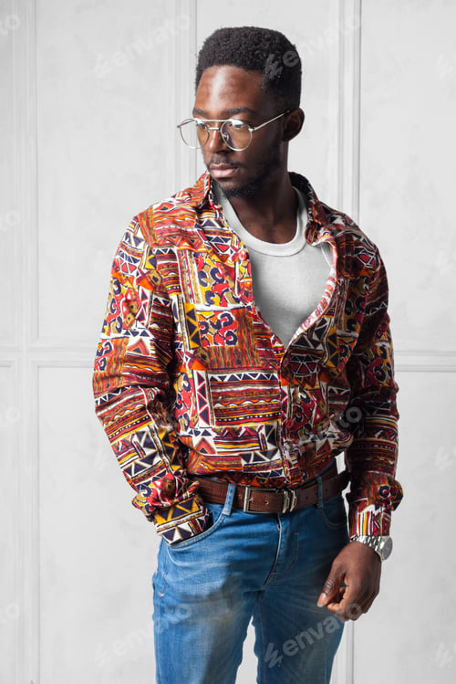 Preview: Man poses in colorful shirt with jeans in studio during daytime
