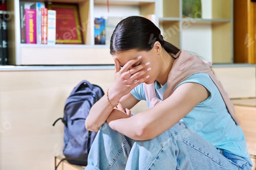 Preview: Upset sad teenage girl high school student sitting on floor in library classroom