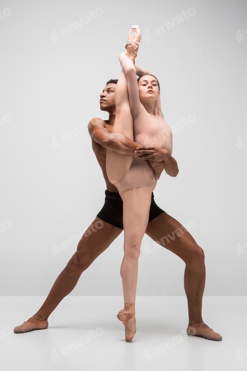 Preview: Couple of ballet dancers posing over gray background