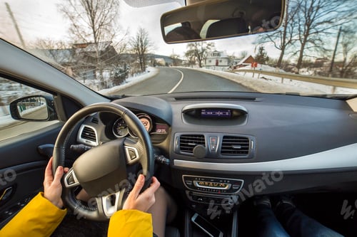 Preview: Modern car interior with driver female hands on steering wheel, winter snowy landscape