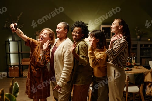 Preview: Happy friends posing at camera of mobile phone