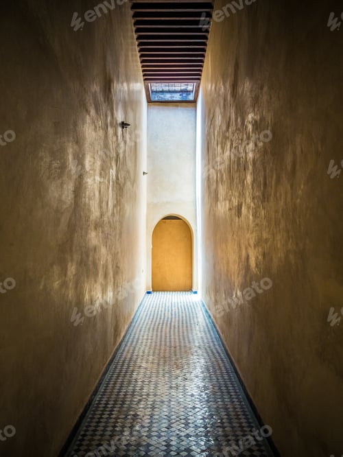 Preview: Vertical shot of a narrow corridor leading to a door in Morocco