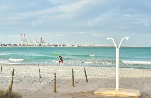 Preview: Couple taking a selfie on the beach with the green sea in the background