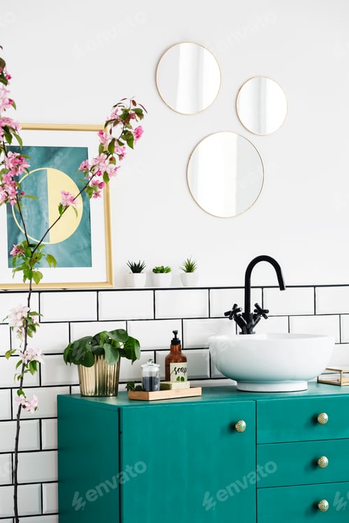 Preview: Mirrors and poster above green cabinet in modern bathroom interi
