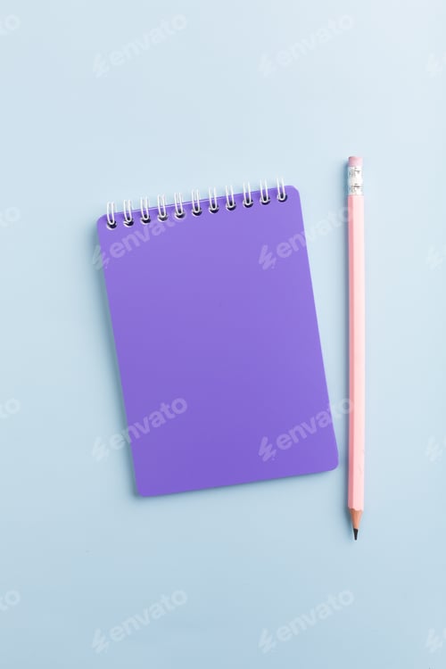 Preview: Purple notebook on a blue background with a pencil