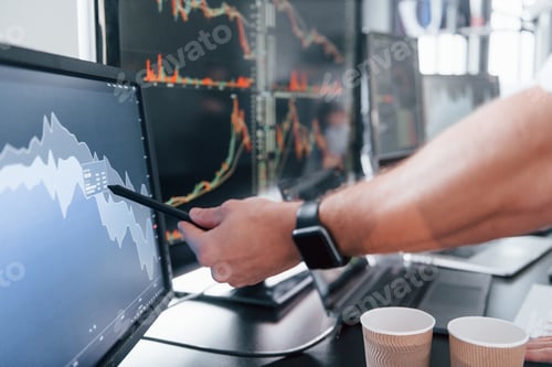 Preview: Close up view of man's hand that points at part of stock graph on display