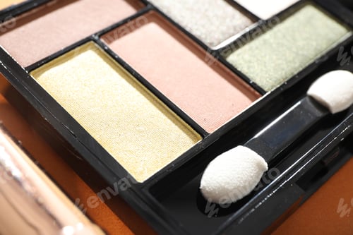 Preview: Eyeshadow palette with applicator on orange background, closeup. Makeup cosmetics