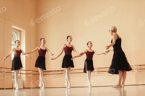 Preview: Graceful ballerinas practicing with mature instructor at ballet studio.
