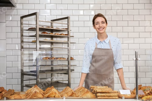 Preview: Beautiful woman near showcase with pastries in bakery shop