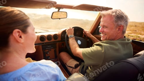 Preview: Retired Senior Couple On Vacation Driving In Classic Sports Car On Road Trip Through Countryside