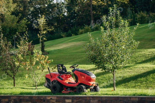 Preview: Lawn mover is on the green grass at daytime
