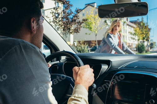 Preview: car driver waiting while young woman crossing road