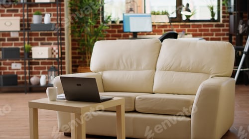 Preview: Interior of modern and cozy apartment living room with comfortable sofa and laptop on coffee table