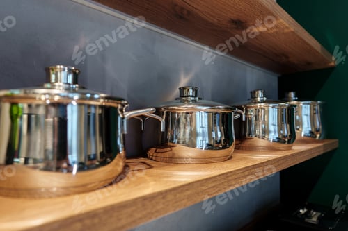 Vista previa: Shining new metal pots on open shelves in store