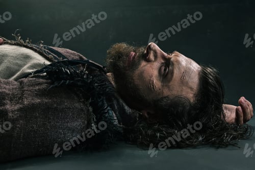 Preview: Halloween Zombie Lying On Paving Asphalt. Vampire Hipster With Red Blood Outdoors. Holiday