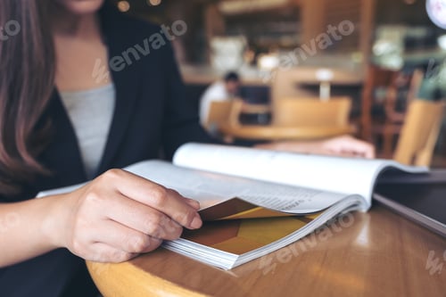 Preview: Closeup image of a business woman reading a book in modern cafe