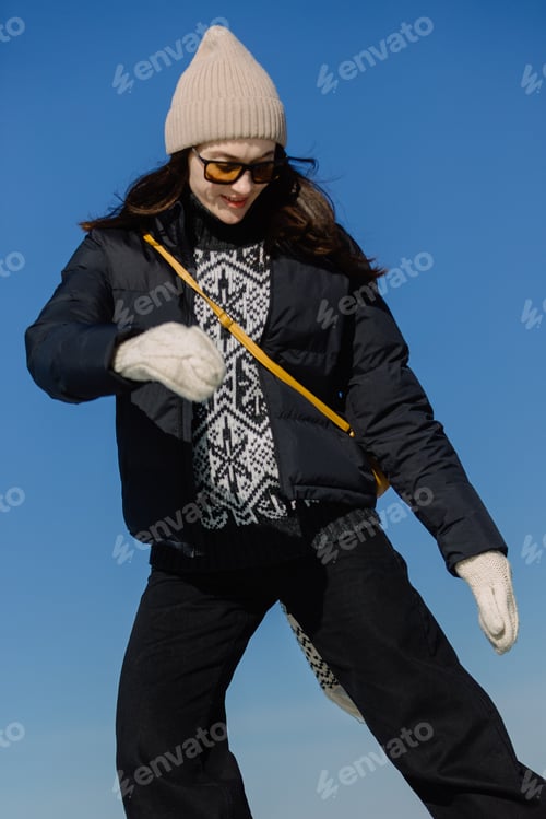 Preview: Young woman ice skating outdoors on frozen lake