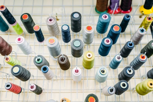 Preview: Colorful threads on spools closeup, side view