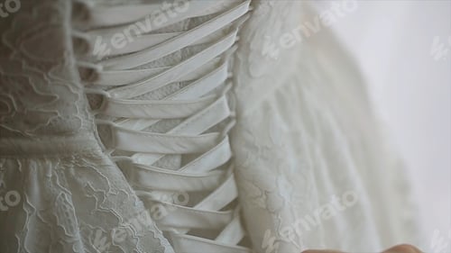 Preview: Morning bride. maid of honor helping the bride with her dress. the bride's lace up dress. Bridesmaid