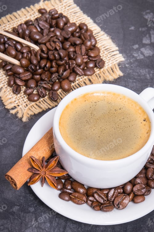 Preview: Coffee in white cup and roasted dark coffee beans with seasonings