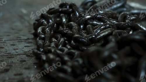 Preview: Close up for a pile of black, metal chains lying on the floor for work in the industry. Chains made