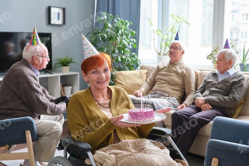 Preview: Elderly woman with cake celebrating her birthday
