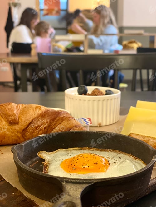 Preview: Breakfast warm food in served in restaurant, fried egg, cheese, croissant and fresh berries in bowl.