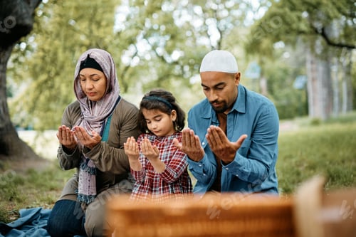 Preview: Religious Muslim family praying while being on picnic in nature.