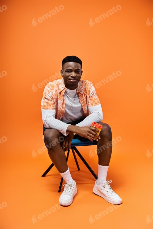 Preview: Stylish Man Contemplating Against Vibrant Orange