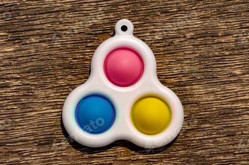 Preview: Simple dimple toy on brown textures background.