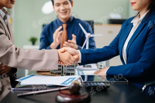 Preview: Two businesswomen shake hands after successful eco-friendly deal as colleague applauds. Great for