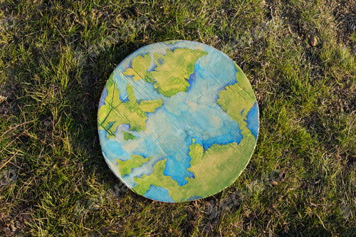 Preview: Painted planet earth lies in the garden. Earth day concept. Protection and love of earth