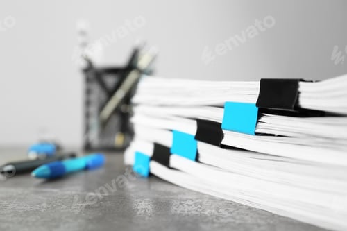 Preview: Stack of documents with binder clips on grey stone table, closeup view. Space for text