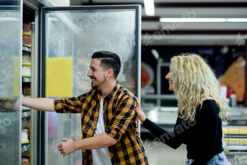 Preview: Couple in a supermarket with shopping cart while grocery shopping