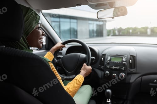 Preview: Vehicle Insurance. Happy Black Muslim Lady Sitting On Driver's Seat In Car
