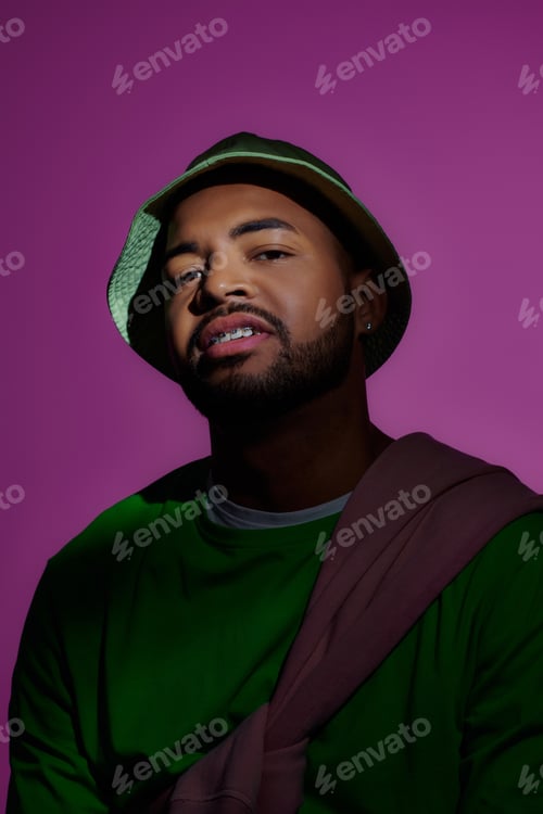Preview: cheerful male model with braces in green sweatshirt and panama smiling at camera, fashion concept