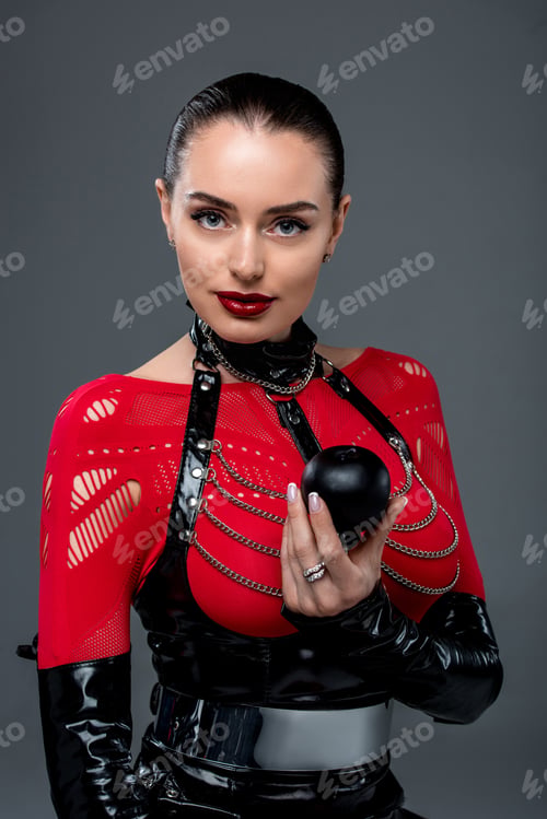 Preview: Attractive hot girl holding black apple isolated on grey