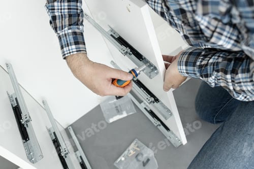 Preview: Man Assembling Furniture using a screwdriver