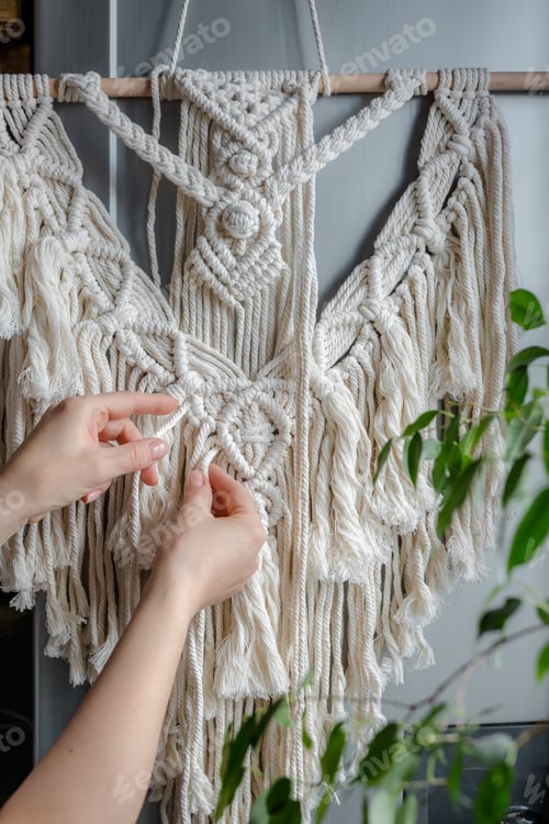 Preview: Macrame. Handmade macrame weaving and cotton threads on a rustic wooden stick. Scandinavian style in
