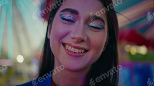 Preview: Cheerful girl enjoying luna park closeup. Beautiful party model looking camera