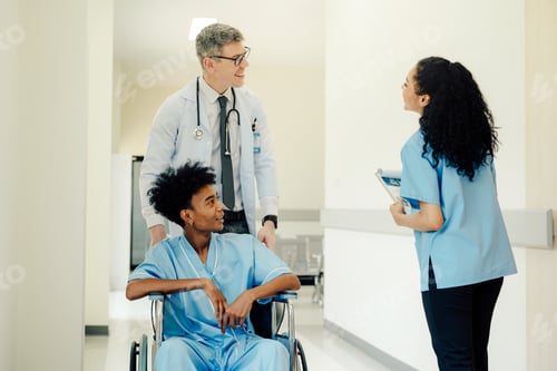 Preview: Young patient man sitting on wheelchair while doctor checking.