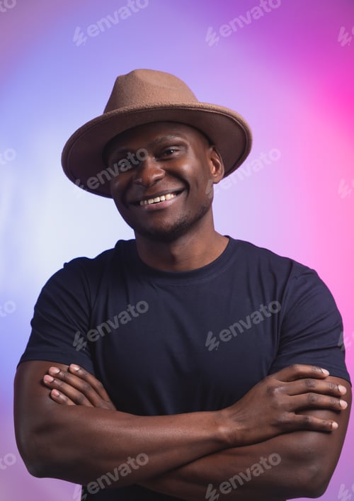 Preview: Smiling happy american african man wear stylish hat on pink and purple background. Festive and party