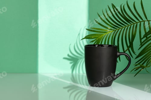 Preview: Porcelain mug and palm leaf against mint background