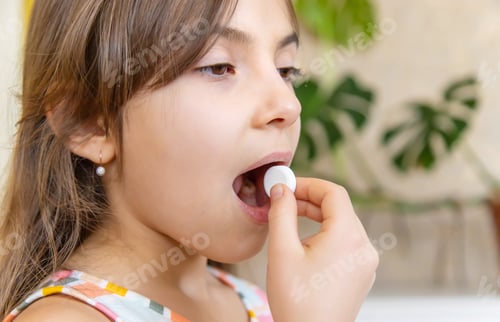 Preview: vitamin c pill to her child. dietary supplements for kids. Selective focus.