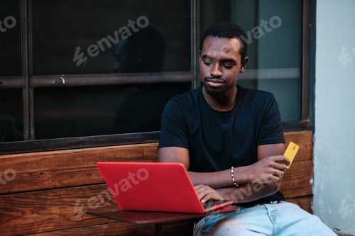 Preview: Young Man Working on Laptop with Credit Card